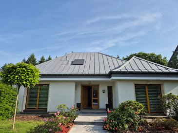 Spaceplus immobilier vous propose une maison individuelle située à Senningerberg, au sein de la prestigieuse commune de Niederanven, dans un quartier résidentiel particulièrement recherché. Cette maison construite en 1978, parfaitement entretenue et rénovée en 2025 séduit par ses volumes généreux, sa polyvalence d'aménagement et son exposition plein Sud. 
Implantée sur un terrain de 6,53 ares, elle développe une superficie habitable d'environ 260m2 et bénéficie d'une vue imprenable sur la forêt, offrant un cadre de vie calme et privilégié à proximité immédiate de Luxembourg-Ville. 
La maison est composée comme suit:
- rez-de-chaussée: un hall d'entrée très spacieux, une cuisine séparée 14m2 et entièrement équipée, un living en L avec le feu ouvert et accès vers le balcon, une chambre ou bureau de 11,60m2, deux grandes chambres à coucher de 16 et 19,20m2 et une salle de bain
- Les combles sont aménagés en suite parentale avec sa salle de bain et dressing.
- Au rez-de-jardin, un grand espace de vie bien éclairé par la baie vitrée dispose d'un l'accès sur la terrasse et vers le jardin bien aménagé et clôturé à l'arrière de la maison. Une grande salle de bain. avec baignoire, douche, et WC ainsi qu'un espace de vie supplémentaire (possibilité d'installer une cuisine) permet d'aménager un logement séparé. La partie technique (chaufferie, buanderie) se situe à côté du garage pour deux voitures (43m2), qui dispose d'un chargeur pour voiture électrique. 
- Dans le jardin arrière se situe un abri de jardin de 9m2 de construction massive (2025).
- Le jardin arboré et clôturé devant la maison est entièrement clôturé par des haies, permettant d'être à l'abri des regards des passants.
- Dans la cour latérale se trouve un Carport pour une voiture.

Confort et équipements téchniques:
- chaudière au gaz neuve en 2026
- volets, Velux et marquise électriques
- panneaux photovoltaïques avec batteries
- isolation des murs
- châssis double vitrage
- système d'alarme
- vidéosurveillance périphérique

Possibilité d'aménager une seconde habitation indépendante au rez-de-jardin avec entrée séparée. 
Vue dégagée sur la forêt.

Environnement et accessibilité: 
- navette gratuite desservant les commerces de la commune, l'aéroport et l'hôpital de Kirchberg
- parc de jeux et piste cyclable à 200m
- accès rapide à Luxembourg-Ville et aux axes autoroutiers.

Pour tout renseignement ou visite, contactez Natacha Bivort au (+352) 661 33 44 22.