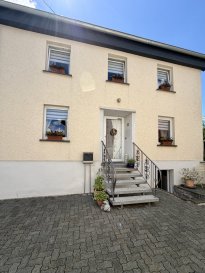 Ein Zuhause zum Ankommen ? liebevoll renoviert und sofort bezugsfertig

In der idyllischen Eifelgemeinde Dahnen, unweit der luxemburgischen Grenze, erwartet Sie dieses freistehende Einfamilienhaus mit viel Charme, großzügigen Nebengebäuden und einem gepflegten Grundstück. Die Immobilie wurde in den Jahren 2022 und 2023 mit viel Liebe zum Detail umfassend modernisiert und präsentiert sich heute in einem ausgezeichneten Zustand. Hier können Sie ohne Renovierungsaufwand direkt einziehen und sich wohlfühlen.

Das ca. 121 m² große Wohnhaus steht auf einem 696 m² großen Grundstück und bietet ausreichend Platz für Familien, Paare oder alle, die großzügiges Wohnen mit vielseitigen Nutzungsmöglichkeiten verbinden möchten.

Raumaufteilung
Bereits beim Betreten empfängt Sie ein freundlicher Eingangsbereich.

Im Erdgeschoss befinden sich:
großzügige Wohnküche
helles Wohn- und Esszimmer
2023 vollständig renoviertes, modernes Badezimmer mit direktem Zugang zur Terrasse und in den liebevoll angelegten Garten

Über eine schöne Holztreppe gelangen Sie ins Obergeschoss mit:
drei Schlafzimmern
separatem WC

Eine weitere Treppe führt in den nicht ausgebauten Speicher, der wertvollen Stauraum oder vielseitige Nutzungsmöglichkeiten bietet.

Modernisierungen
Die umfangreichen Renovierungen sorgen für zeitgemäßen Wohnkomfort:
neues Badezimmer (2023)
Kunststofffenster mit Doppelverglasung (2022)
neue Haustür und Innentüren (2022)
Dachsanierung (2022)
Photovoltaikanlage auf dem Dach
Batteriespeicher mit 9,8 kWh
elektrische Nachtspeicherheizung, unterstützt durch die PV-Anlage
Außenbereich

Das gepflegte Grundstück bietet zahlreiche Nutzungsmöglichkeiten:
gemütliche Terrasse
kleiner, liebevoll angelegter Garten
Garage
zwei Außenstellplätze
ehemaliges Stallgebäude, ideal als Werkstatt, Hobbyraum oder Lagerfläche
zusätzlicher Abstellraum

Fazit

Dieses gepflegte Einfamilienhaus vereint modernen Wohnkomfort mit ländlichem Charme und bietet dank der großzügigen Nebengebäude zahlreiche Möglichkeiten für Hobby, Handwerk oder zusätzlichen Stauraum. Eine Immobilie, die durch ihren hervorragenden Zustand, ihre hochwertige Modernisierung und ihre attraktive Lage überzeugt ? ideal für alle, die sofort einziehen und sich zu Hause fühlen möchten.