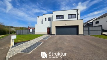 Maison contemporaine Lumineuse - 161 m2 hab - terrain clos .  ESCHERANGE : PROCHE FRONTIERE +++ Visite VIrtuelle sur demande +++
 Maison contemporaine Lumineuse   161 m2 habitables   terrain clos de 7,38 ares
 En exclusivité, découvrez cette maison contemporaine construite en 2018, offrant 161 m2 habitables (198 m2 au total) sur un terrain clos de 7,38 ares.
 La maison se trouve dans un environnement résidentiel calme, apprécié pour sa proximité avec le Luxembourg. Les accès vers Thionville et les principaux axes sont rapides, ce qui facilite les déplacements quotidiens, notamment pour les frontaliers. La commune propose les commodités essentielles à proximité (écoles, commerces), tout en conservant un cadre de vie tranquille.
 Au rez-de-chaussée, vous profiterez d'une entrée avec placard, d'un bel espace de vie d'environ 50 m2, lumineux et climatisé, ouvert sur la terrasse et le jardin, ainsi que d'une cuisine ouverte entièrement équipée avec électroménager Siemens. Un passage dérobé, dissimulé dans les éléments de cuisine, permet d'accéder au cellier. Un bureau, un WC avec lave-mains et un garage double complètent ce niveau.
 À l'étage, le palier avec deux placards aménagés dessert une suite parentale climatisée d'environ 30 m2 avec dressing, salle d'eau privative et terrasse, deux chambres spacieuses, une salle de bains avec douche et baignoire, une buanderie / lingerie et un second WC.
 Maison récente, bien équipée et soignée, offrant des prestations de qualité : RT2012, isolation extérieure, pompe à chaleur, volets motorisés, double vitrage, adoucisseur d'eau, nombreux rangements, escalier métal et bois, finitions soignées.
 Située à Escherange, dans un environnement calme et recherché, elle bénéficie d'un accès rapide vers le Luxembourg et les grands axes.
  
 Les caractéristiques et prestations : Construction RT2012, Isolation par l'extérieur 14cm, Pompe à chaleur, Climatisation, double vitrage, volets motorisés, cuisine équipée (plaque induction, hotte, four, micro-onde, lave-vaisselle SIEMENES et cave à vin LIEHBERR), salles d'eau meublée, Dressing et placards aménagés, adoucisseur d'eau, vide sanitaire 80cm, porte de garage motorisée, escalier métal et bois, tablettes de fenêtre en chêne massif.
  
 INFOS ET VISITES : +336 03 40 96 27 ou +352 661 409 627
 DPE A / A
 Estimation des coûts annuels : entre 750 EUR et 1 070 EUR par an Prix moyens des énergies indexés sur les années 2021, 2022, 2023 Numéro enregistrement DPE (ADEME) : 2657E0825669X
 Honoraires charges acquéreur inclus (3,25 %)
