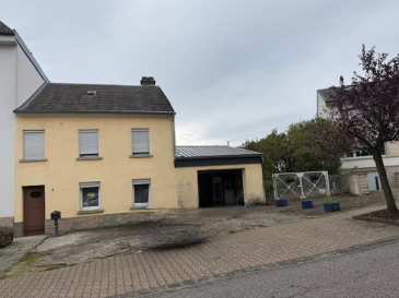 Cette  maison jumelée à vendre se situe au cœur de Sandweiler, une ville pittoresque du Luxembourg. Proposée par AGENCE REINERT CARLO, cette propriété exceptionnelle est disponible exclusivement sur athome.lu.

Détails de la propriété

Découvrez une maison lumineuse de 130 m² sur deux étages construite en 1920, placé sur un vaste terrain de 4,73 ares. Avec trois chambres, une salle de bains, et une toilette, chaque membre de la famille aura son espace personnel. Profitez d'une agréable terrasse de 25 m², idéale pour des moments de détente en plein air, ainsi que d'un  jardin de 300 m². Un garage, un parking intérieur, et quatre places de stationnement extérieur offrent des solutions de stationnement abondantes. Les caractéristiques traditionnelles telles qu'une cave et un grenier ajoutent au charme de la maison. L'énergie est assurée par le chauffage au gaz. Ce bien est équipé d'une connexion fibre optique, parfaitement adapté aux besoins technologiques modernes.
La parcelle se situe en zone d'habitation HAB-1.

Équipements à proximité

Sandweiler est une commune réputée pour son atmosphère accueillante et familiale. Les écoles de qualité et diverses options éducatives satisfont les besoins des plus jeunes. Profitez de commerces variés et de restaurants où vous pourrez apprécier la gastronomie locale. Des parcs et autres espaces de loisirs procurent des opportunités idéales pour se détendre ou pratiquer des activités physiques. Vous trouverez également des services de santé compétents à proximité. Enfin, la commune bénéficie d'excellentes liaisons de transport facilitant l'accès aux environs et à la ville de Luxembourg.

Ne manquez pas cette occasion unique! Pour organiser une visite, contactez-nous via le formulaire de contact ou par téléphone.