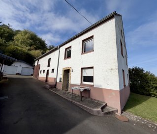 Ehemaliger Bauernhof mit großem Grundstück und vielseitigen Nebengebäuden

Viel Platz für Wohnen, Hobby und Handwerk charmantes Bruchsteinhaus auf 1.226 m² Grundstück

Dieser ehemalige Bauernhof aus dem Jahr 1950 vereint ländlichen Charakter mit vielfältigen Nutzungsmöglichkeiten. Das traditionelle Bruchsteinhaus wurde im Laufe der Zeit umgebaut und bietet mit teilweise renovierten Zimmern, vorhandener Einbauküche und unterschiedlichen Bodenbelägen eine individuelle Wohnbasis.

Das großzügige Grundstück mit ca. 1.226 m² bietet viel Freiraum zur persönlichen Gestaltung. Eine Terrasse mit ca. 20 m² lädt zum Verweilen im Freien ein. Ein besonderes Plus sind die ehemaligen Stallgebäude, die sich ideal als Lagerfläche für Brennholz und Gartengeräte sowie als Werkstatt oder Hobbybereich eignen. Eine Garage und ein zusätzlicher Stellplatz ergänzen das Angebot.

Der nicht ausgebaute Speicher bietet zusätzlichen Stauraum und gegebenenfalls weitere Perspektiven, vorbehaltlich der baurechtlichen Prüfung. 
Ausstattung und Eckdaten 
- Baujahr ca. 1950, später umgebaut 
Energieträger 
Elektro, Holz 
- Bruchsteinbauweise 
- Grundstück ca. 1.226 m² 
- Terrasse ca. 20 m² 
- Ehemalige Stallgebäude mit Lager- und Werkstattmöglichkeiten 
- Garage und Außenstellplatz 
- Einbauküche vorhanden 
- Teilweise renovierte Zimmer 
- Bodenbeläge aus Laminat, Fliesen und Kieferdielen 
- Badezimmer und separates WC 
- Elektro-Nachtspeicherheizung und Holzofen 
- Dacheindeckung aus Ziegel 
- Nicht ausgebauter Speicher 
Eine interessante Immobilie für alle, die ein Haus mit Geschichte, großzügigem Grundstück und praktischen Nutzflächen suchen. Lassen Sie sich bei einer Besichtigung vom Charakter und den Möglichkeiten dieses Anwesens überzeugen.