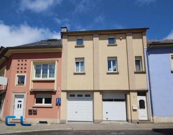 Maison mitoyenne en très bon état général, se composant d\'une belle cuisine équipée ouverte sur le salon, d\'une petite dépendance avec barbecue, de trois chambres à coucher, d\'un grand espace très lumineux pouvant servir de salle de jeux, salle de sport ou autre, d\'une salle de douche, d\'une grande cave et d\'un garage.
Cette maison se situe à proximité des écoles, de l\'hôpital, de l\'arrêt de bus etc. 
Disponible à l\'acte notarié 
La commission d\'agence est entièrement à charge du vendeur. 

Ref agence : DLVH1