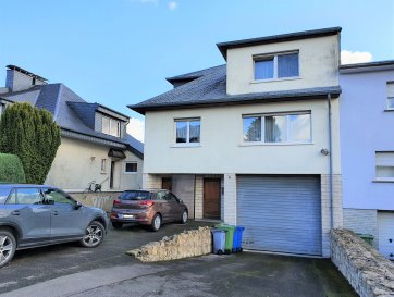 Situé à Belvaux, aux abords de la route d'Esch et donc facilement accessible,  à ± 5min de l'A4, ce bien immobilier atypique dispose d'une surface totale de ± 520 m².

Il se décline en 2 parties : à l'avant, une maison jumelée, d'une surface habitable de ± 157 m², à l'arrière un hall de stockage / garage de ± 280 m²

La partie habitation comprend le hall du rez de chaussée ± 4m² avec des escaliers qui mènent vers le premier étage et comprenant un palier ± 15 m² donnant accès au séjour ± 32 m², à la cuisine équipée ± 16 m², un WC séparé ± 3 m², une buanderie / débarras ± 5 m², une salle de bains ± 8 m² et deux chambres ± 12 et 24 m², cette dernière donne accès à la terrasse sur garage de ± 184 m²

Le deuxième étage est composé d'un palier ± 7 m² souvrant sur un salon de ± 32 m² une salle de douche avec wc ± 3 et un débarras dressing ± 2 m², des espaces de rangement / grenier sont accessible sous le toit ±17 m²

Le GARAGE sur le devant ± 37 m² et directement conecté à un bureau ± 15 m² et un wc séparé ± 5 m² ainsi qu'au hall de stockage / garage ± 280 m² avec une hauteur sous plafond de ± 3.6m dont l'accès est à l'arrière du bâtiment, et accessible par camionnettes,

Le tout se situe sur un terrain entièrement clos de 13a28ca.
