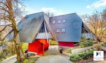 

Située sur les hauteurs de Schrassig avec une vue panoramique sur la nature environnante, cette atypique maison d'architecte datant de 1975 se présente comme suit:

La maison, en bois, repose sur deux blocs en béton - l'un comprenant les installations techniques ± 12 m², l'autre, l'entrée, la cage d'escaliers ± 9 m² et une cave ± 6 m² située sous l'escalier. Sur ces deux blocs de béton vient s'appuyer une structure en bois soutenant la partie habitable ; les murs extérieurs sont légèrement en biais, ce qui accentue l'impression de vivre en hauteur.

Le bel étage comprend le salon ± 18 m², la salle à manger ± 16 m², la cuisine d'origine équipée ± 17 m², trois chambres de ± 13, 13 et 15 m² - la plus grande disposant d'un dressing ± 6 m² et d'une salle de bain ± 6 m² (rénovée en 2000) - et enfin, une salle de douche ± 4 m². Des couloirs contournant la cage d'escaliers desservent ces différentes pièces.

L'étage supérieur comprend un espace bureau ± 4 m², trois chambres de ± 14, 16 et 19 m², une petite salle de douche ± 3m², un coin débarras/dressing et enfin, un grenier non aménagé ± 17 m².

Généralités :

- Maison hors du commun profitant d'une vue exceptionnelle ;

- Nombreux petits balcons et grande terrasse ± 36 m² sous les arbres au rez-de-chaussée ;

- Les mesures sont toutes prises à hauteur approximative de 2 m ;

- La maison a toujours été bien entretenue mais des travaux de modernisation sont à prévoir (cuisine, salles de douche, etc.) ;

- Au calme tout en restant proches des points de services : transports en commun, commerces, ...
