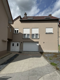 Charmante et lumineuse maison moderne à Bettendorf

Découvrez cette superbe maison mitoyenne nichée dans un quartier calme et résidentiel de Bettendorf, où confort, modernité et élégance se rencontrent. Avec ses espaces généreux et ses finitions soignées, cette demeure offre un cadre de vie idéal pour une famille en quête de sérénité et de fonctionnalité.

Dès l'entrée, un garage spacieux vous accueille, accompagné d'un local technique pratique. À côté du garage, une pièce dispose des raccordements pour installer une douche et/ou une sauna, tandis qu'une autre chambre supplémentaire peut facilement être aménagée en espace de rangement ou en salle de sport selon vos besoins.

Au premier étage, une cuisine ouverte et entièrement équipée s'ouvre sur un séjour baigné de lumière. Cet espace convivial mène directement à une grande terrasse, parfaite pour profiter des journées ensoleillées ou partager des moments conviviaux entre amis. À ce niveau se trouvent également une salle de douche avec WC, un bureau et une première chambre, le tout agrémenté de finitions haut de gamme et d'un élégant sol en granite.

Le deuxième étage est dédié à l'espace nuit, comprenant deux chambres confortables, une vaste salle de bain avec baignoire et une décoration raffinée. Un dressing généreux peut facilement être transformé en chambre supplémentaire. Les chambres bénéficient d'un parquet chaleureux qui apporte une ambiance accueillante.

La maison est équipée de fenêtres double vitrage et d'un chauffage au sol, garantissant confort et efficacité.

En complément du garage, des places de stationnement extérieures sont disponibles pour votre confort.

Cette maison représente une opportunité rare à Bettendorf pour ceux qui recherchent un cadre de vie paisible, moderne et fonctionnel, avec des possibilités d'aménagement flexibles pour le bien-être et le sport.

Pour plus d'informations ou pour organiser une visite, contactez-nous au 621686850. Nous nous adaptons à vos besoins et serons ravis de vous accueillir.