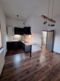 Very nice apartment located on the 1st floor of a condominium including an entrance with cupboard, equipped kitchen with furniture, oven, hobs, extractor hood, dishwasher, bedroom with dressing room, living room, bathroom with bathtub and vanity unit, separate WC, individual closed cellar.  
Parking spaces at the back of the building (private courtyard).  
Individual gas heating.